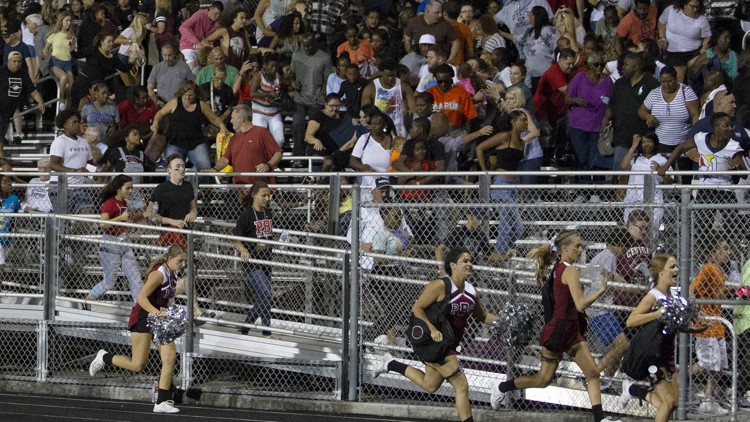 Fans, cheerleaders and football players at the Palm Beach Central game run to safety after hearing gun shots. 