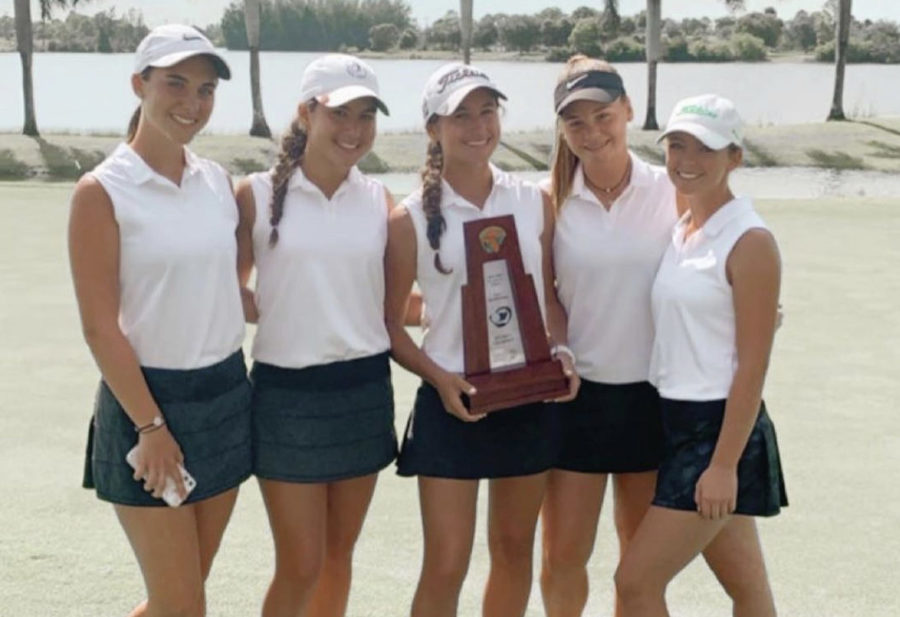 The girls golf team with their winning trophy.