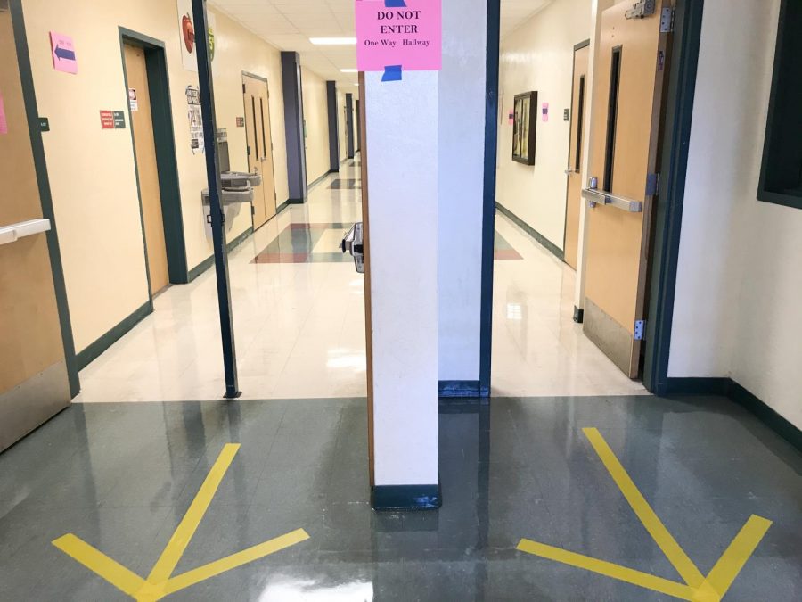 Jupiter High administrators and custodians set up one-way hallways to minimize crowding during COVID-19.