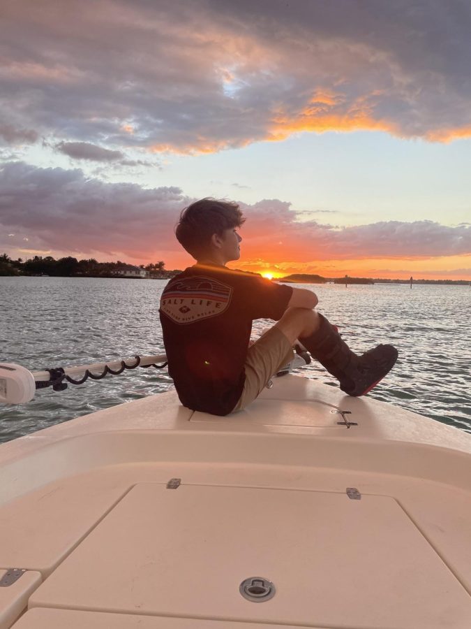 Hudson Domb watches sunset from the bow of his boat after his accident.