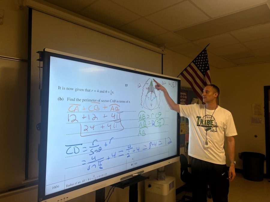 Brian Goodman stands in front of his class reviewing previous AICE Math exam problems.