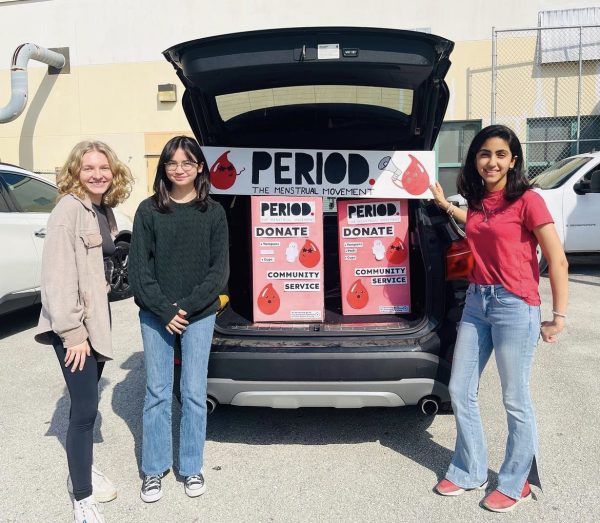 Officers of the PERIOD Club with boxes filled with donated menstrual products. 
Pictured Left to Right: Mina Robinson, Ryan Choe and Maryam Alrekabi.