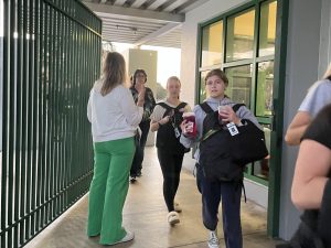 Students practice entering the school with their backpacks on the front. 