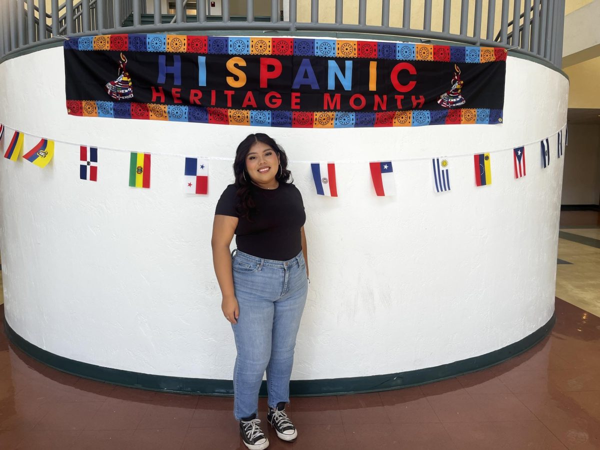 Latinos in Action member celebrating with the banner in the atrium 