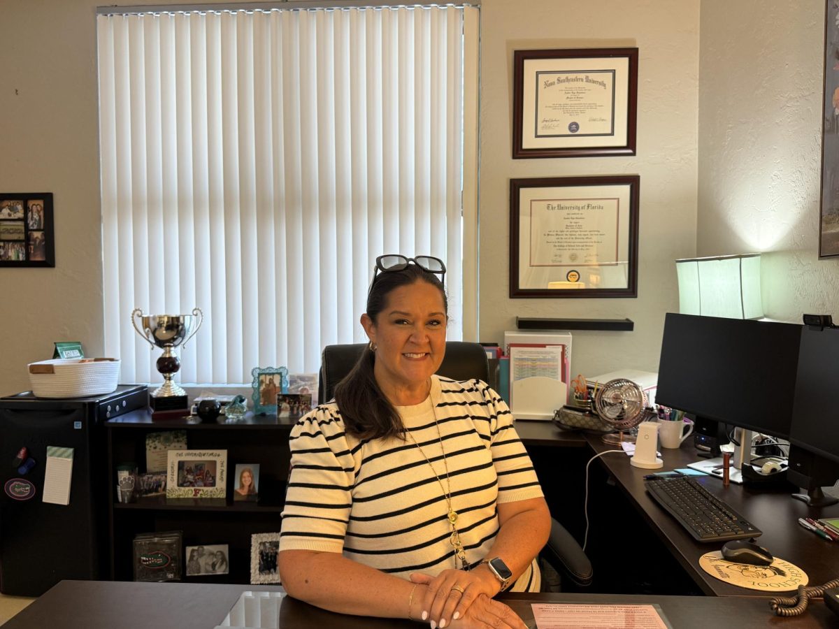 New Principal: Ms. Saunders in her office with awards and degrees displayed in the back. 