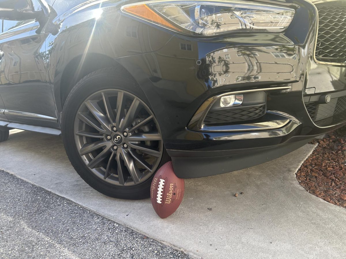 Football propped against car