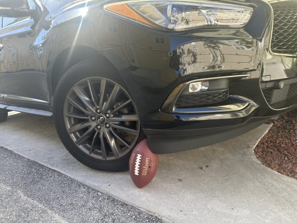 Football propped against car